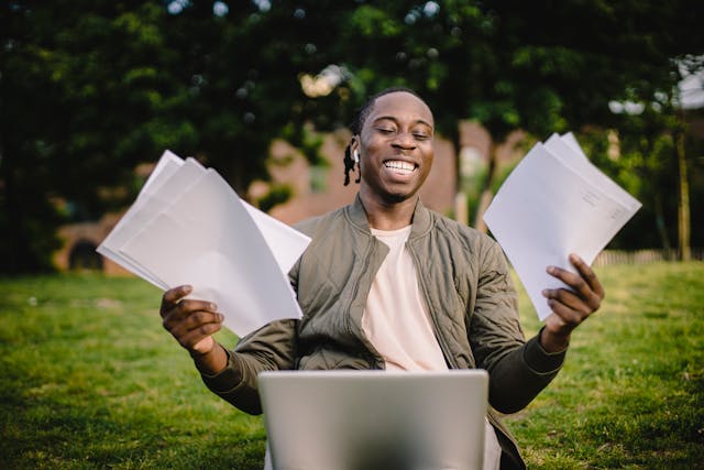 man smiling holding papers