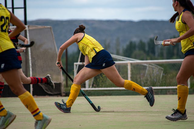 girl playing field hockey